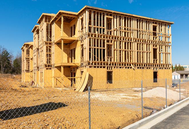 workers protected by temporary barrier fence during building maintenance in Newhall