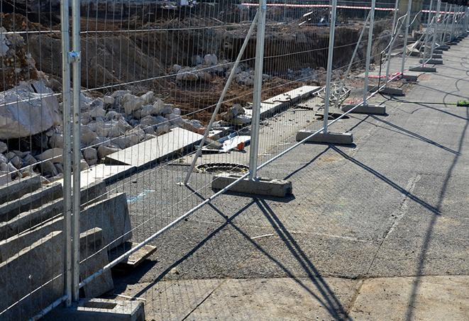 temporary fence panels lined up on a street corner, directing traffic and pedestrians